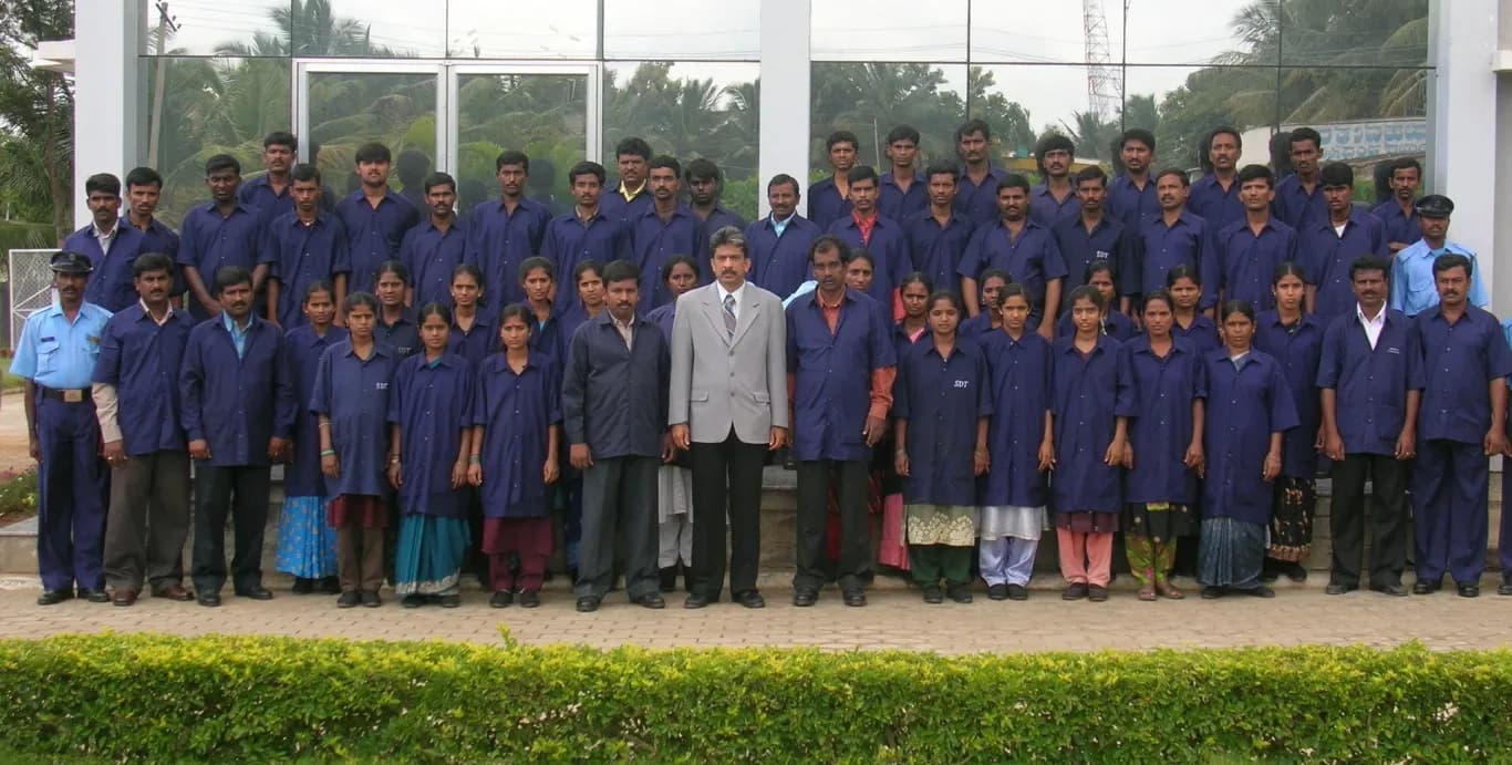 The Sanwa workforce, in blue work uniforms, standing in rows outside the plant.